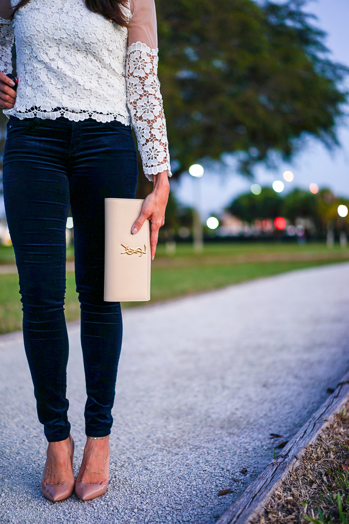 Best Luxury Designers Handbags blogger Amanda Mercado wears AG Jeans blue velvet legging with nude YSL monogram clutch
