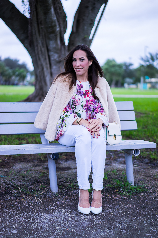 Amanda wearing a faux fur jacket layered over an Intermix Alberta Ruffle floral blouse