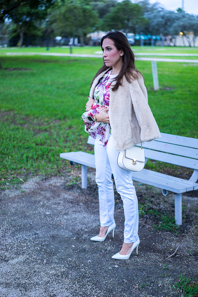 Amanda wearing an Intermix Alberta Ruffle Floral Blouse paired with white AG Jeans, styled in a chic casual outfit.