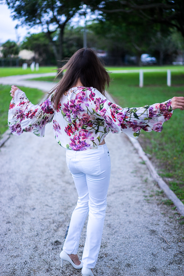 Amanda wearing an Intermix Alberta Ruffle floral blouse with a soft ruffled design and colorful floral print.