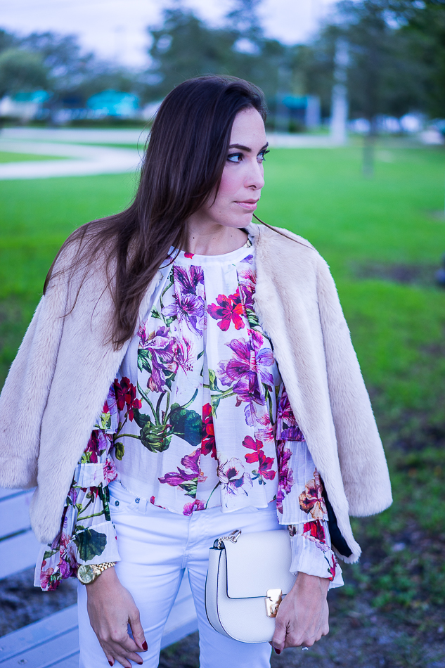 Amanda wearing an Intermix Alberta Ruffle floral blouse styled with a blush faux fur jacket