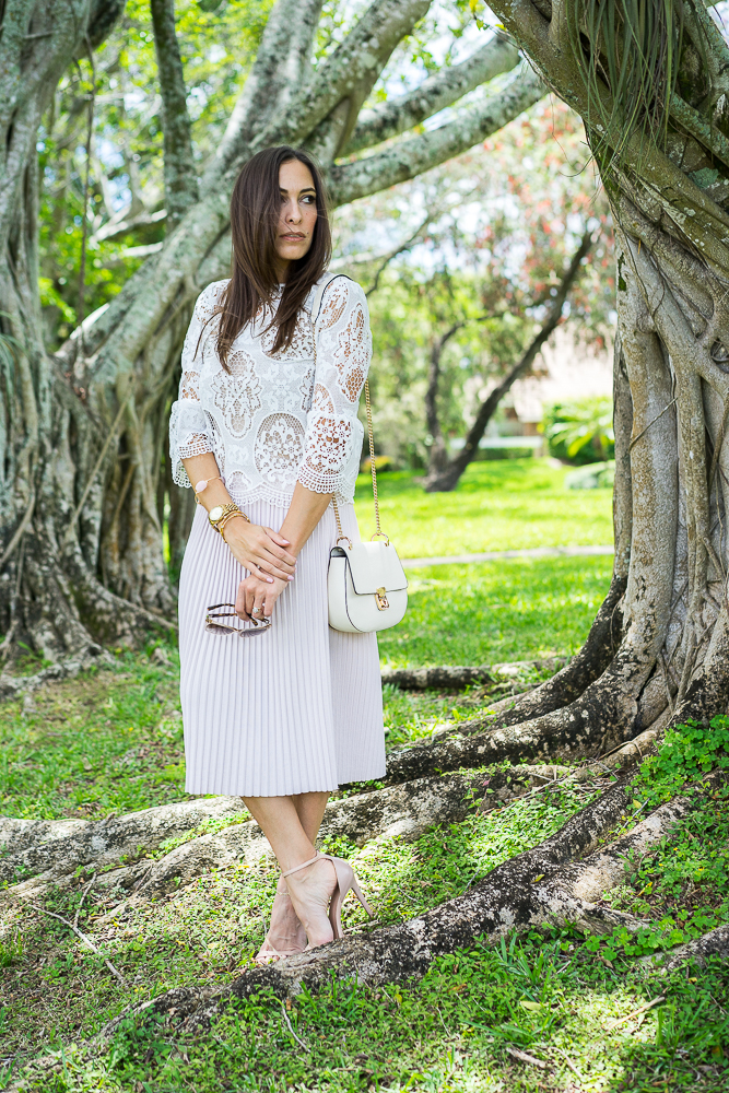 Top Quality Luxury Handbag Shop wearing White lace bell sleeve top, blush pleated skirt and white bag