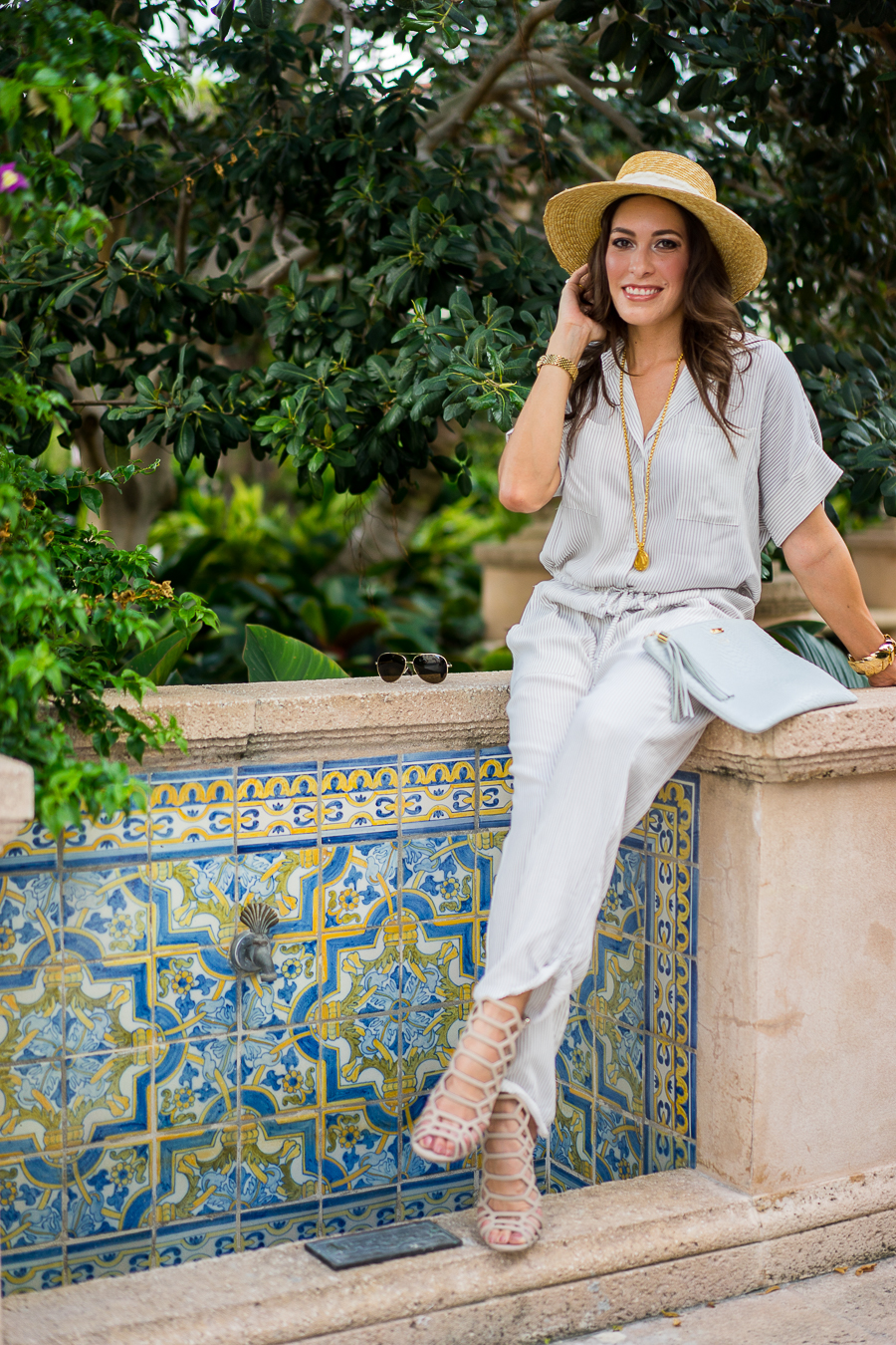 Best Luxury Designers Handbags Blogger Top Quality Luxury Handbag Shop Faithfull the Brand Striped Jumpsuit, with gold accessories and straw hat and holding her Gigi New York Uber clutch