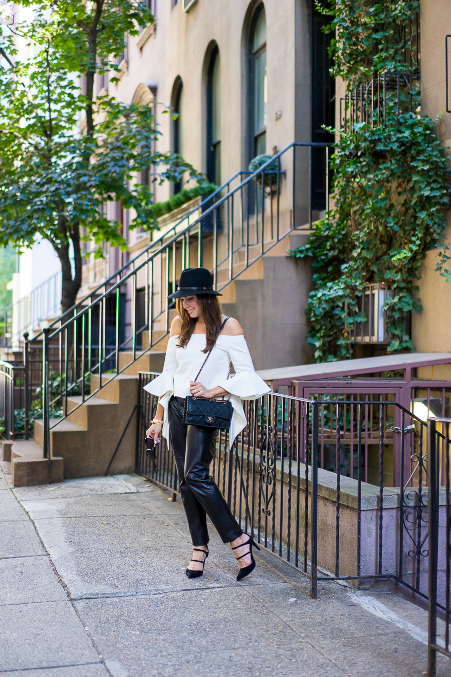 Best Luxury Designers Handbags blogger wearing chicwish white off-the-shoulder top with milly black leather cropped pants and classic chanel bag with a rag and bone fedora and strappy-black-sandals