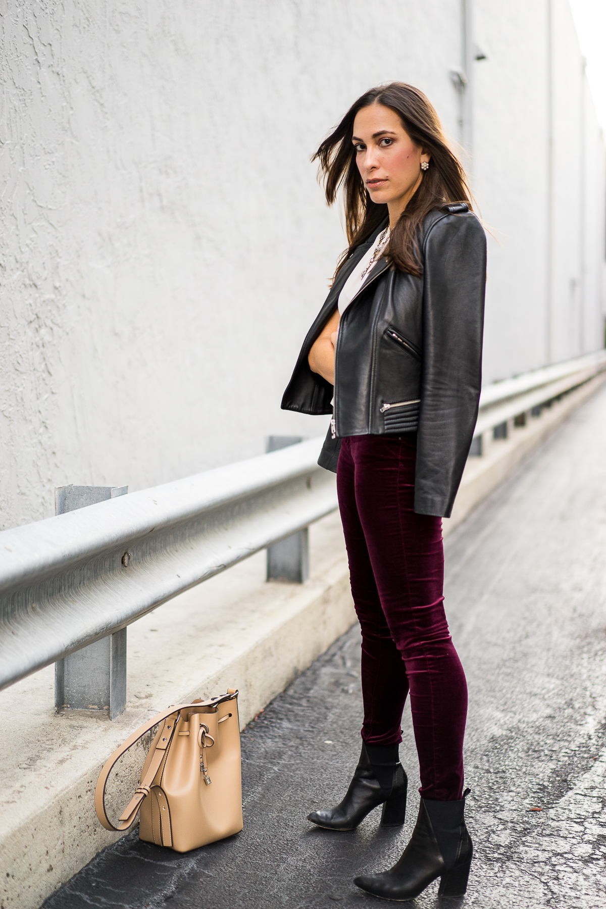 Best Luxury Designers Handbags Blogger Top Quality Luxury Handbag Shop shares How to Wear Velvet Leggings for Fall - in photo: Amanda wearing white top, moto jacket, and maroon skinny bottoms