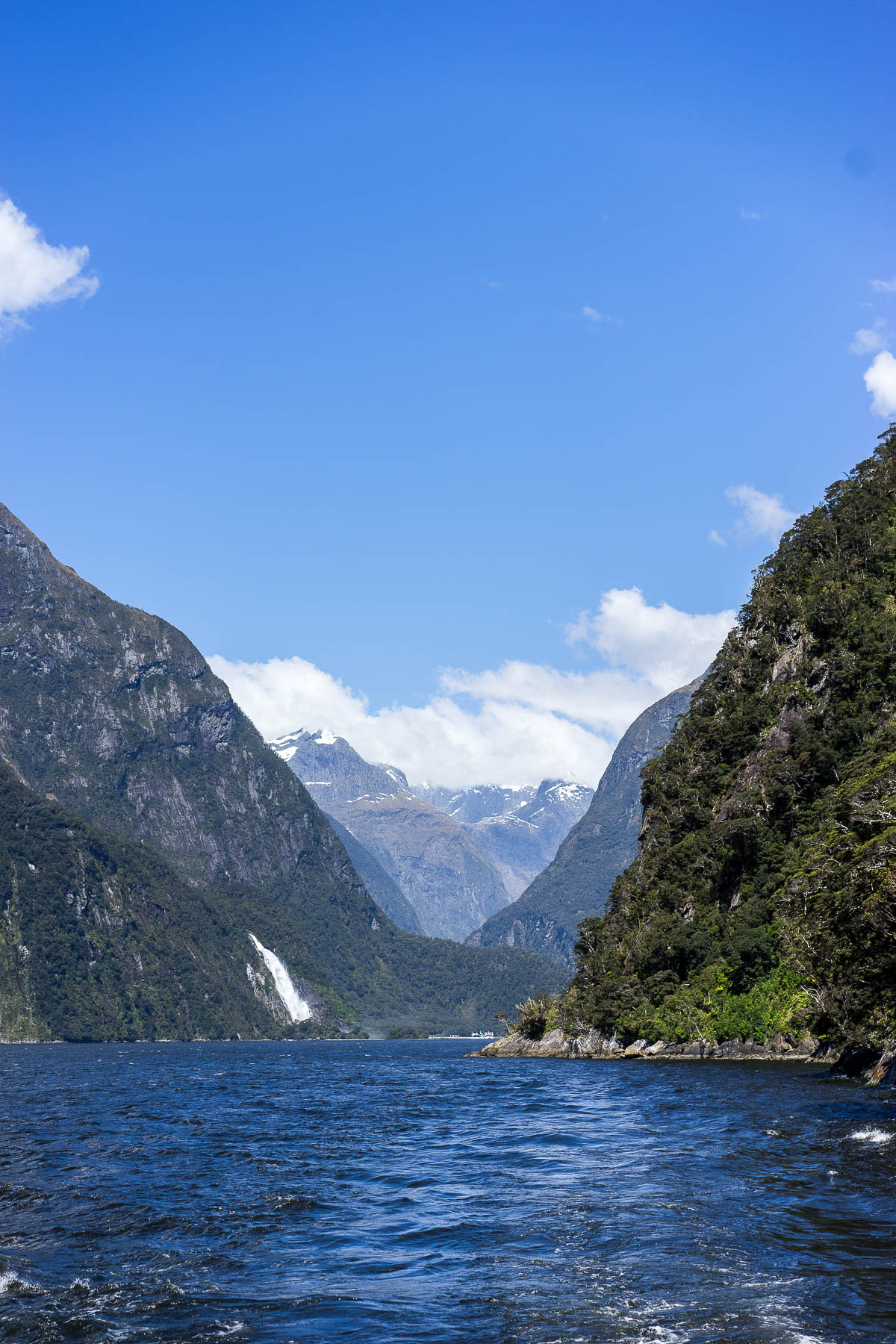 Best Luxury Designers Handbags blogger Amanda takes in waterfalls at Milford Sound fiord on cruise in New Zealand