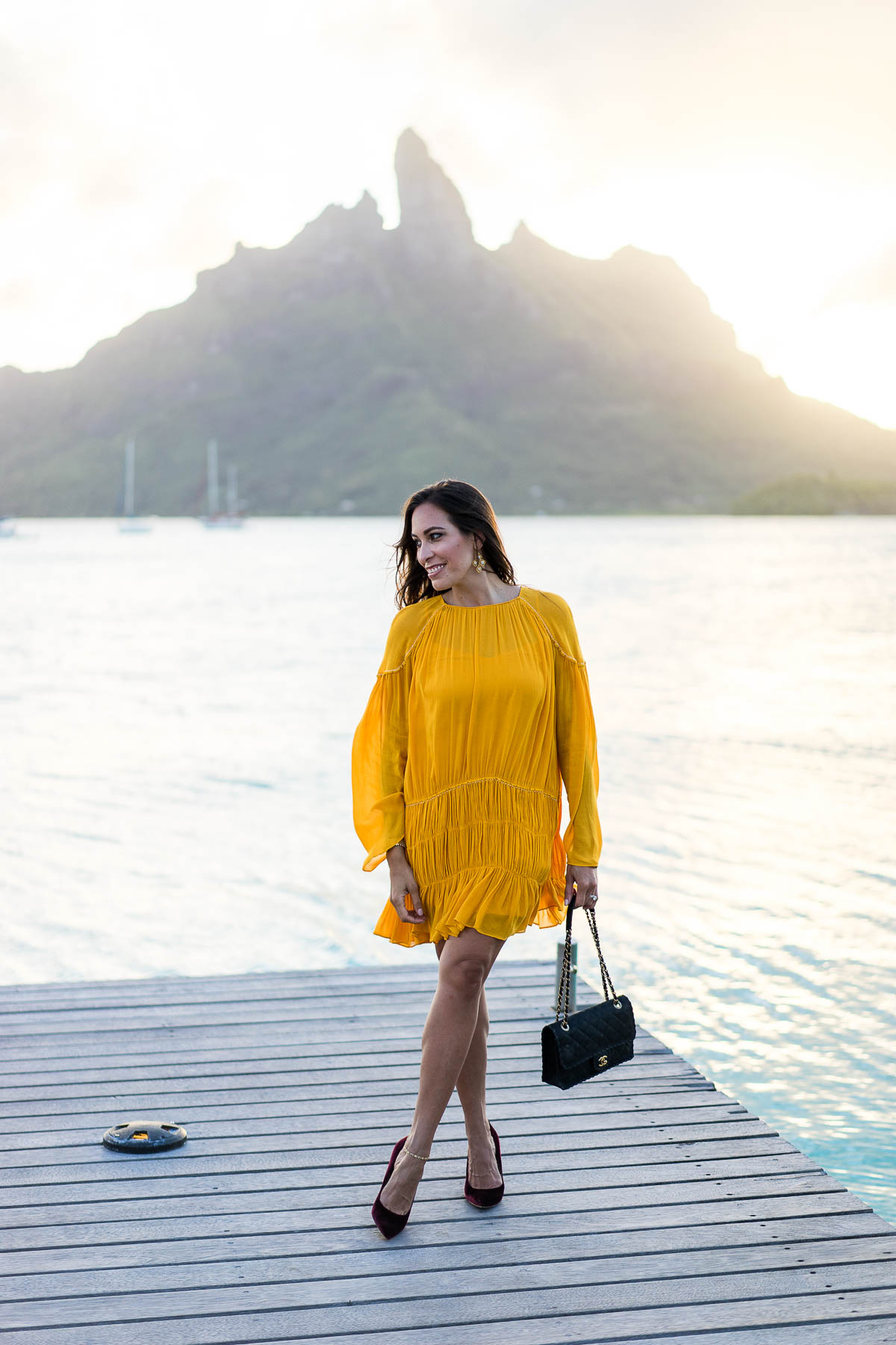 South Florida blogger Amanda from Best Luxury Designers Handbags wears mustard yellow dress to dinner in Bora Bora