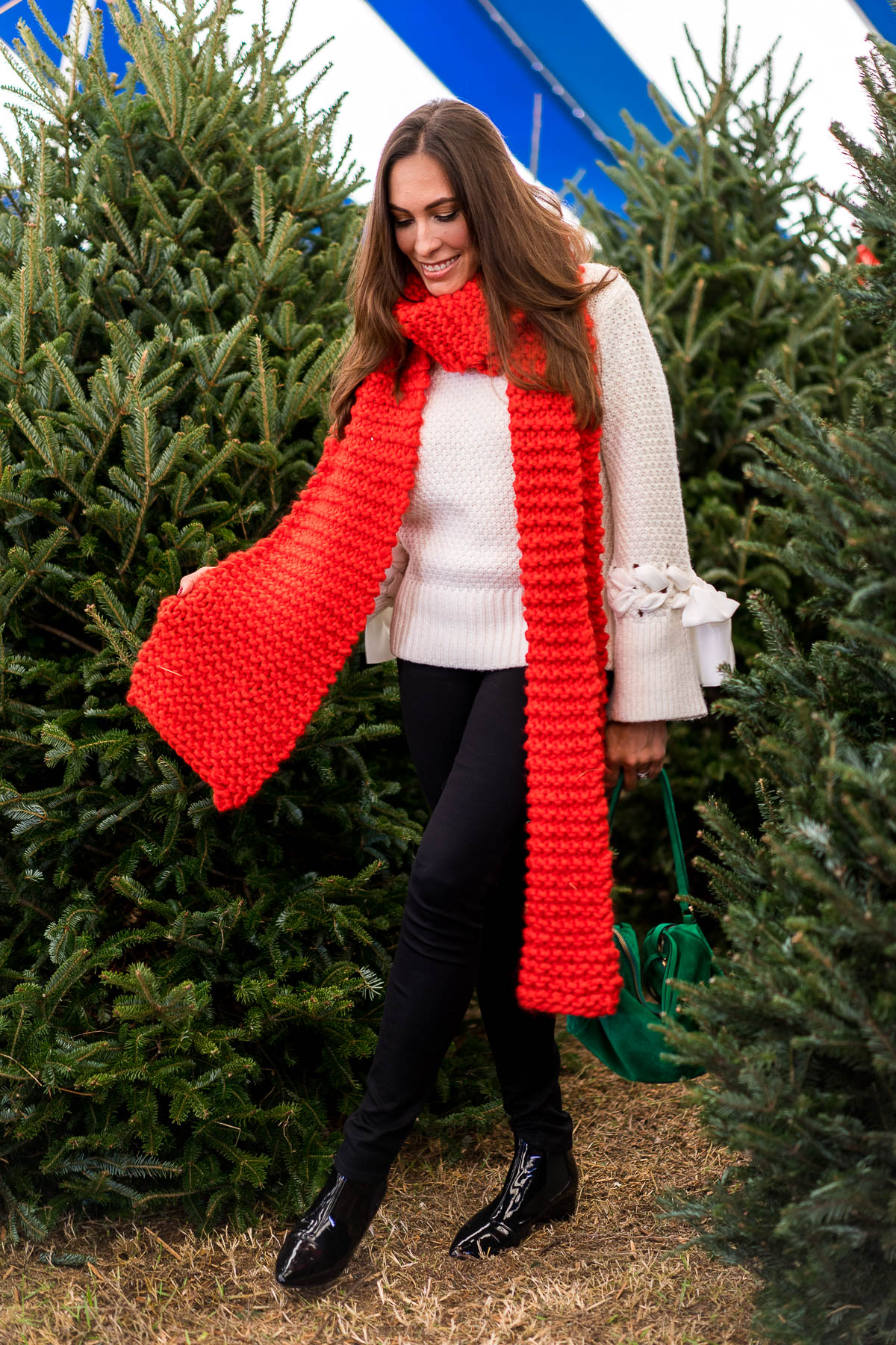 Amanda from Best Luxury Designers Handbags fashion blogger wears oversized red scarf with cream colored sweater to visit Christmas Trees Pompano