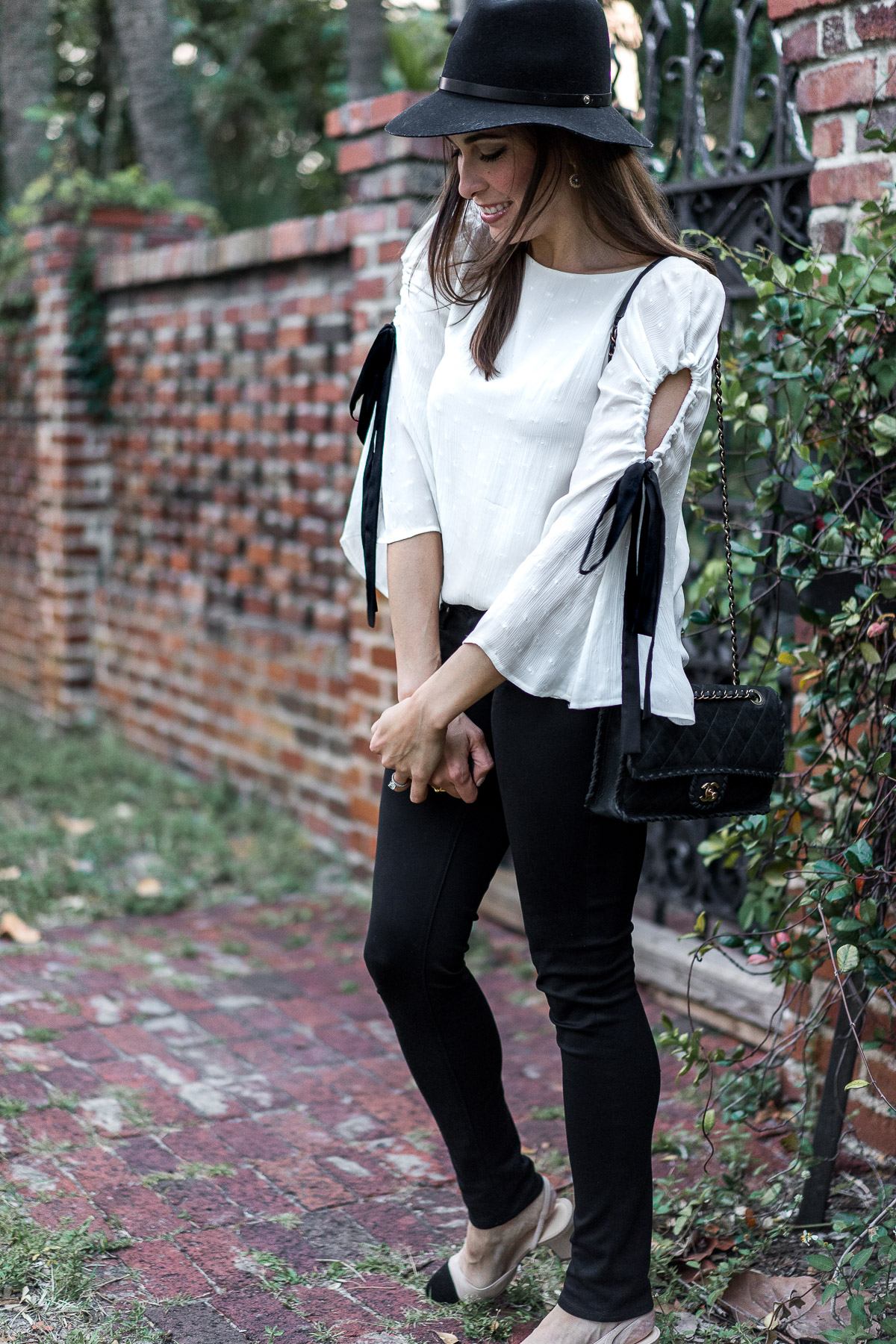 Pretty Club Monaco bell sleeve top with black ribbon tie styled by South Florida blogger Amanda of Best Luxury Designers Handbags worn with Chanel suede bag and black AG Leggings jeans