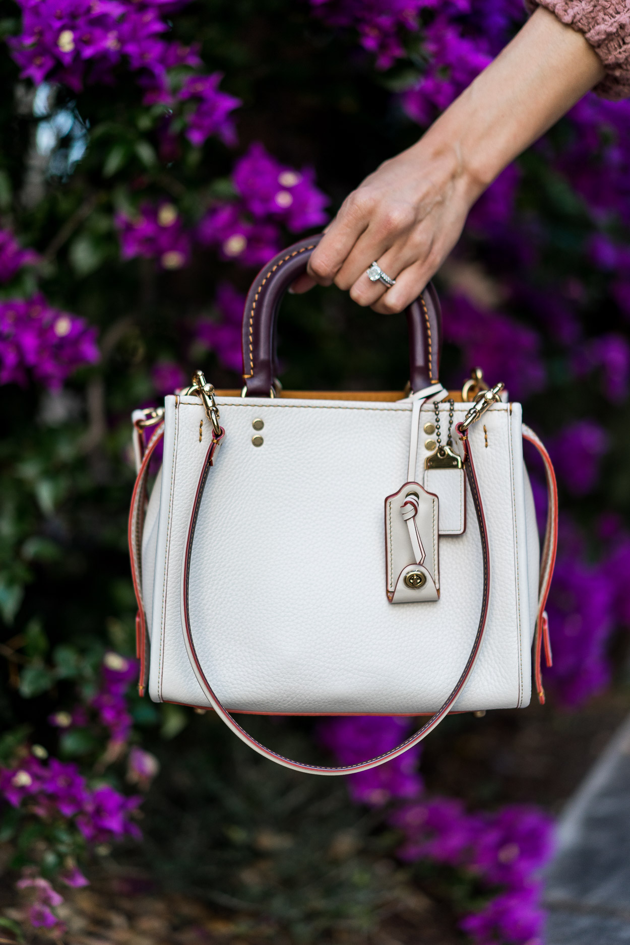 Chic white Coach Rogue bag is styled by Amanda of Best Luxury Designers Handbags blog with Free People oversized cardigan and Cami NYC velvet top