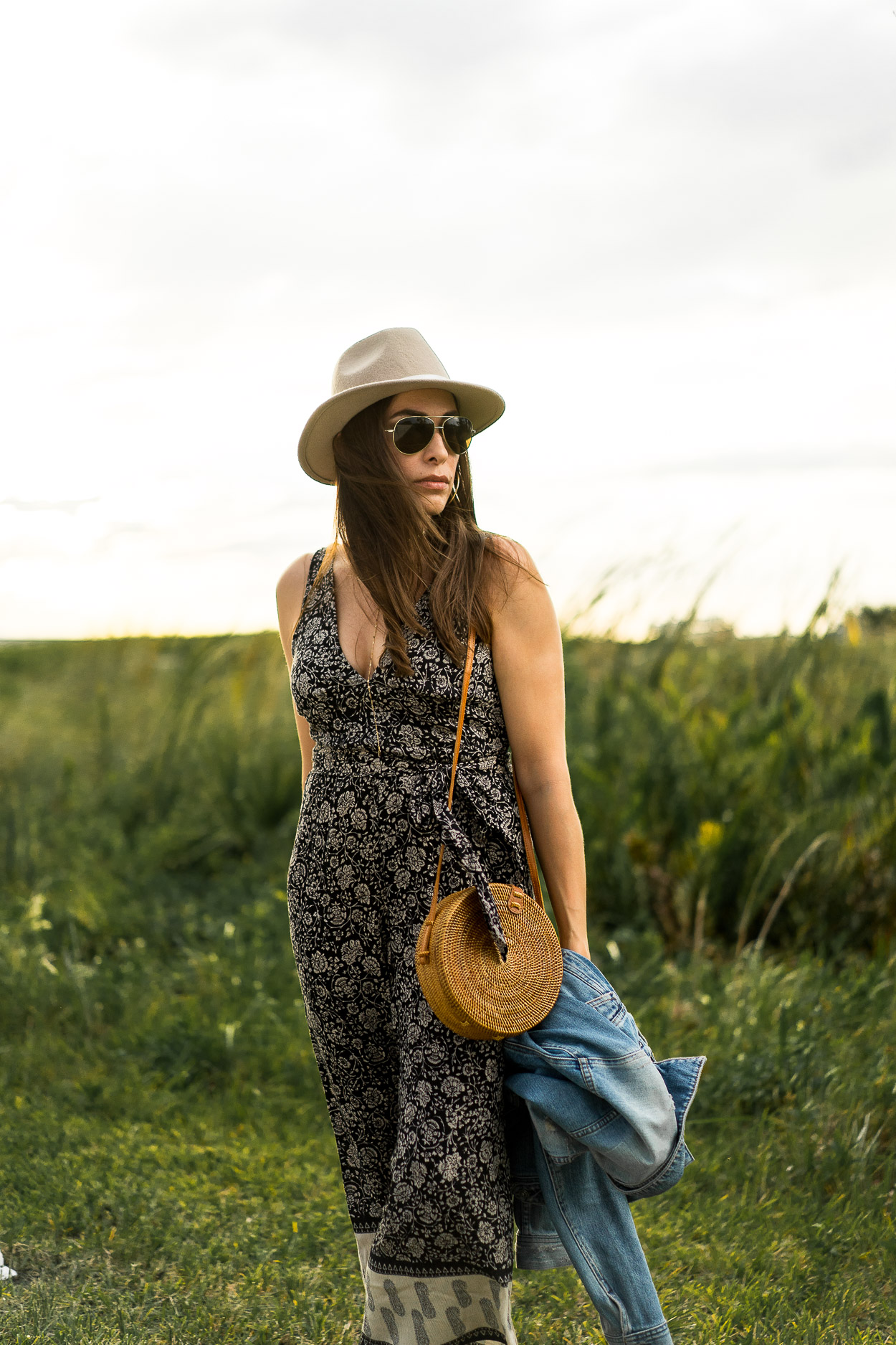 South Florida fashion blogger Amanda of Best Luxury Designers Handbags wearing jumpsuit with chic Summer accessories including round basket bag and classic denim jacket