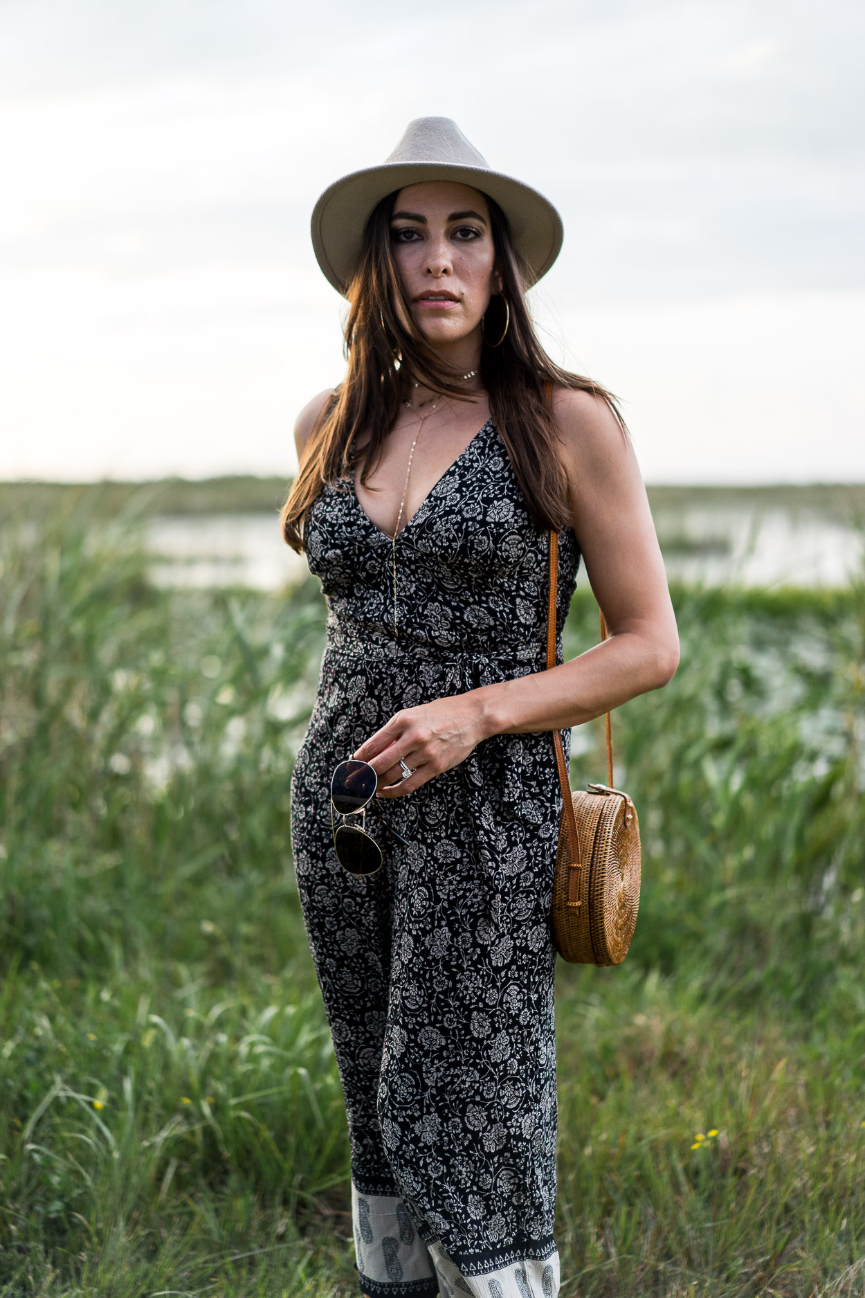 Blogger Amanda of Best Luxury Designers Handbags wears boho style jumpsuit by Amuse Society with Summer style must haves including round basket bag and gold Parpala jewelry