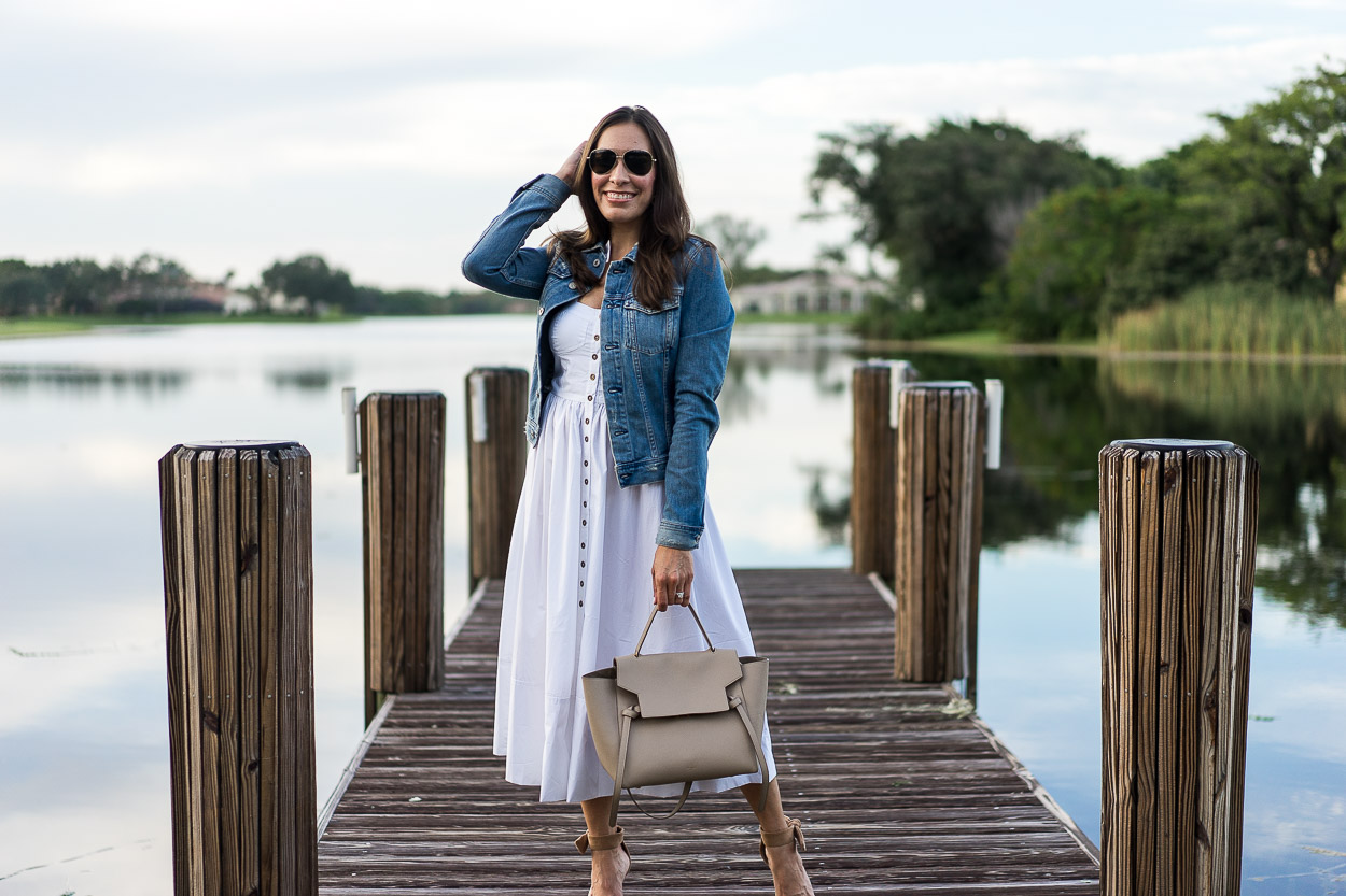 Chicwish white cami dress is styled at the lake by fashion blogger Amanda of Best Luxury Designers Handbags with neutral accessories like Celine belt bag and Banana Republic bow heels