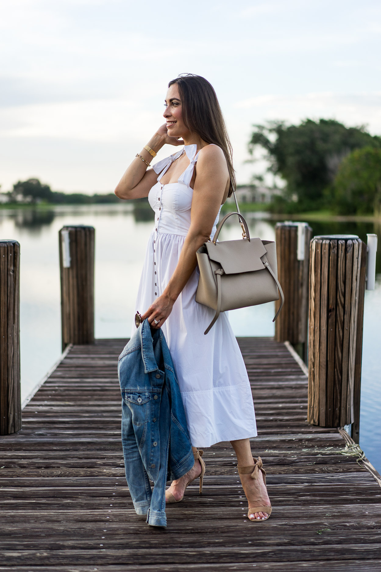 Best Luxury Designers Handbags blogger Amanda: wearing Classic summer white dresses from Chicwish and holding a denim jacket