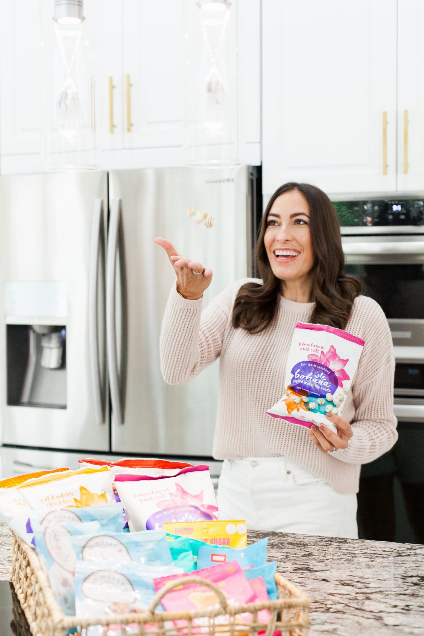 Healthy Snack Ideas for Working From Home by popular Florida lifestyle blog, Best Luxury Designers Handbags: image of a woman holding a bag of Bohana popped water lily seeds. 