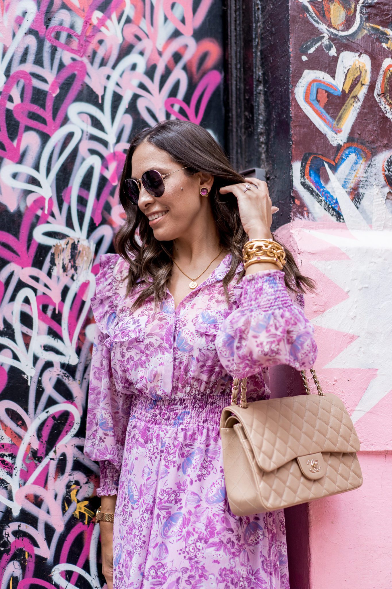 Julie Vos Favorites by popular Florida fashion blog, Best Luxury Designers Handbags: image of a woman standing by a heart wall mural and wearing a purple dress, Julie Vos Catalina Hinge Bangle and Julie Vos Savannah Demi Link Bracelet.