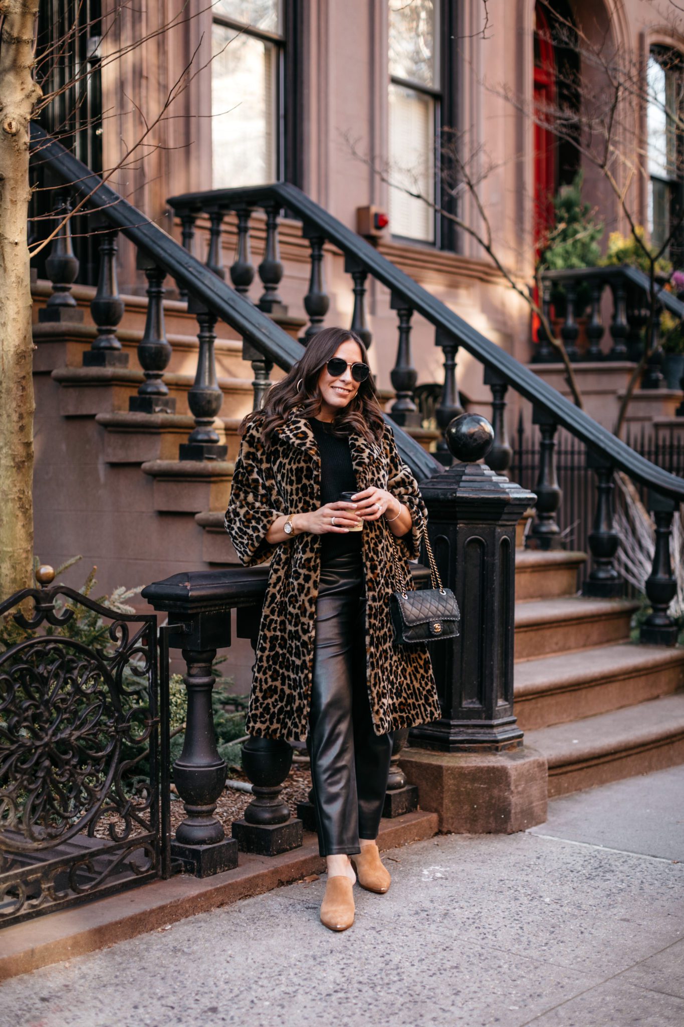 Chanel bag outfit ideas wearing leather pants, top, and animal print sweater